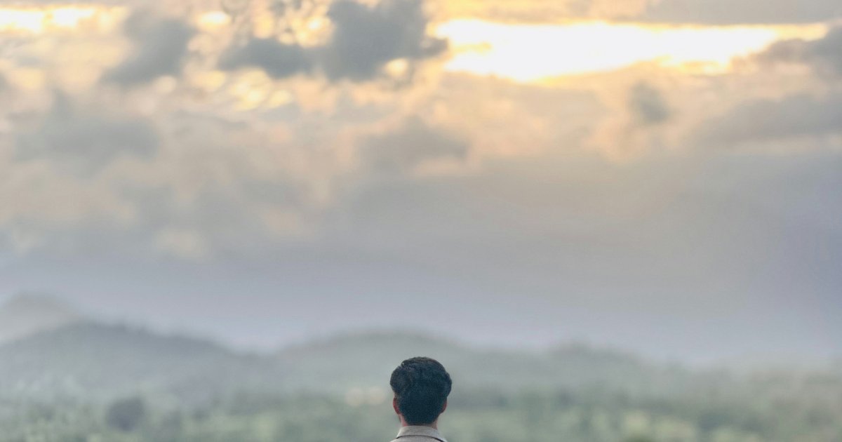 Person standing peacefully in nature, releasing tension